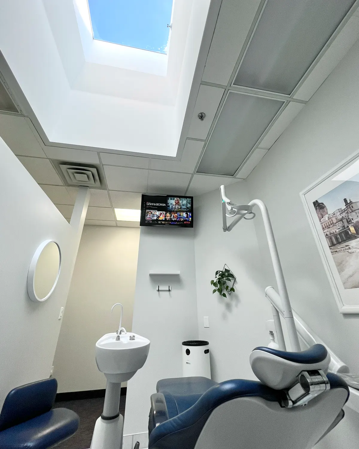 Wide view of a Headon treatment room looking up at the skylight, with a dental chair and sink below
