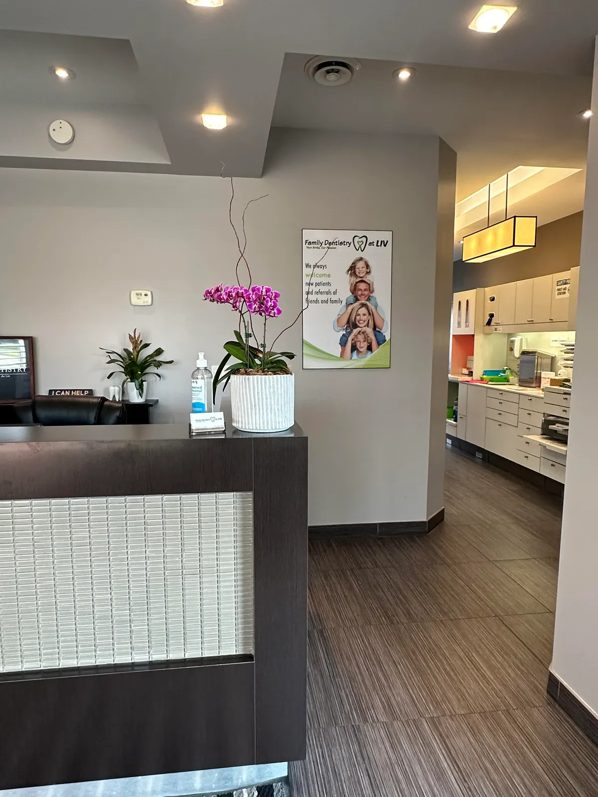 LIV reception desk with an orchid and a welcome poster, with the clinical area visible beyond