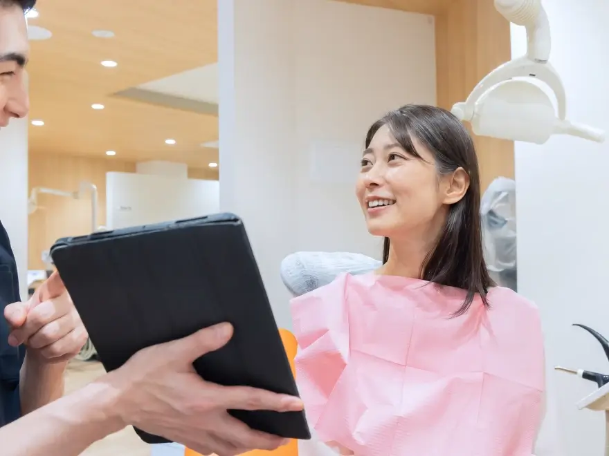 A patient chatting with her dentist while reviewing a tablet