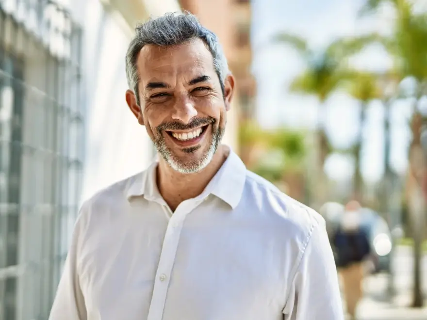 A smiling man in a white shirt outdoors