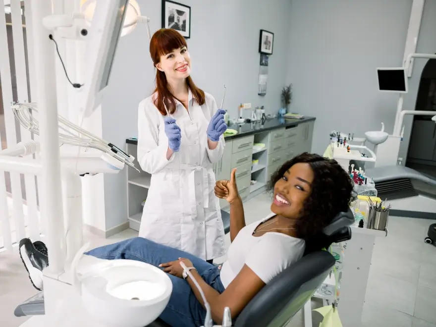 A dentist standing beside a patient reclined in the dental chair