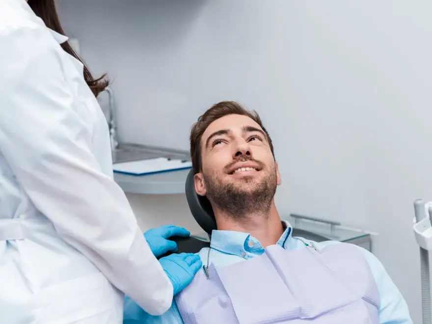 A smiling patient reclining in the dental chair