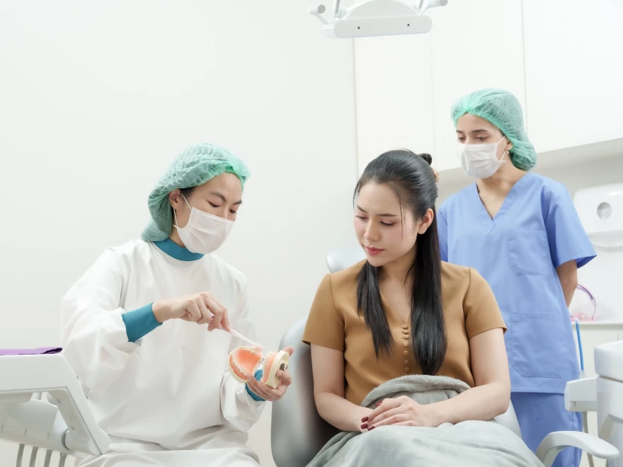 A patient talking with two dental team members
