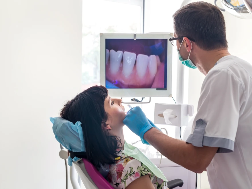 A patient and dentist looking at a screen together