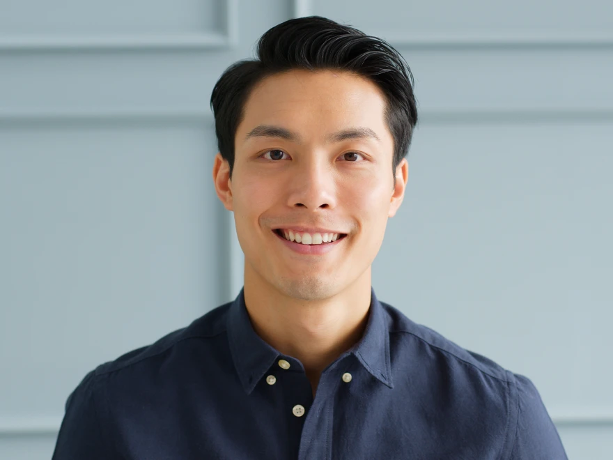 A smiling man in a navy shirt