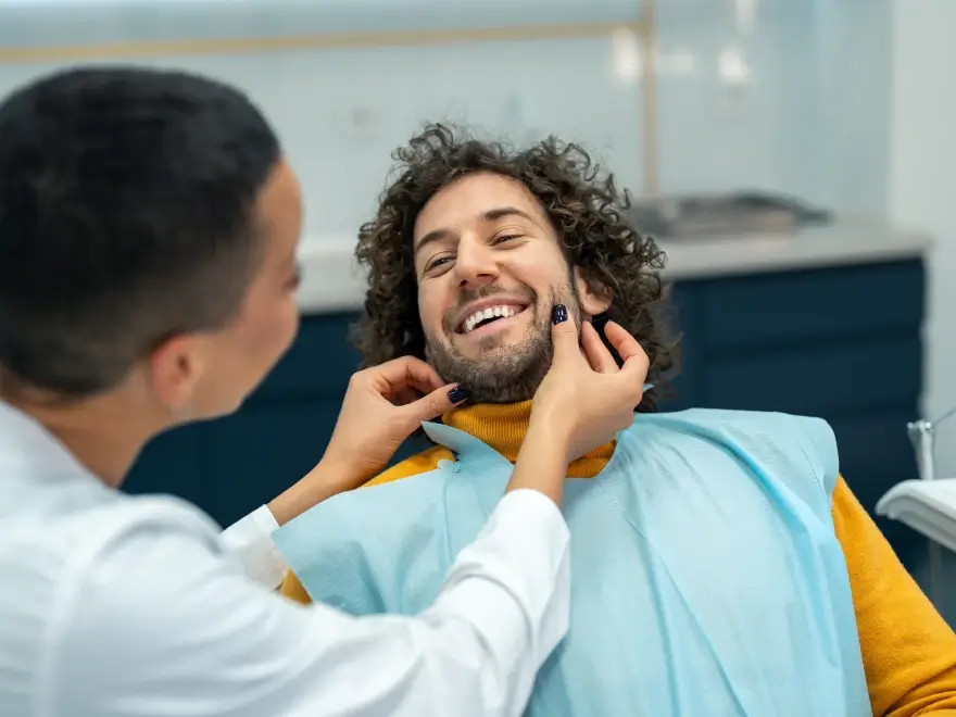A smiling patient being examined in the dental chair