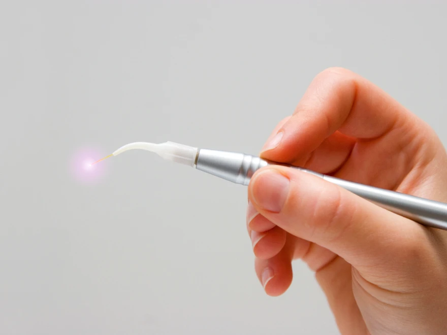 A dental laser handpiece with a soft pink light